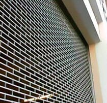 Rideau métallique à grille articulée pour devanture de commerce
